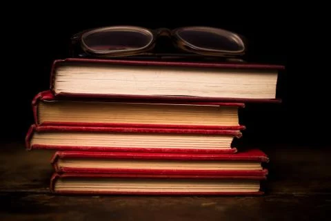 Stack of books with a pair of glasses Photos