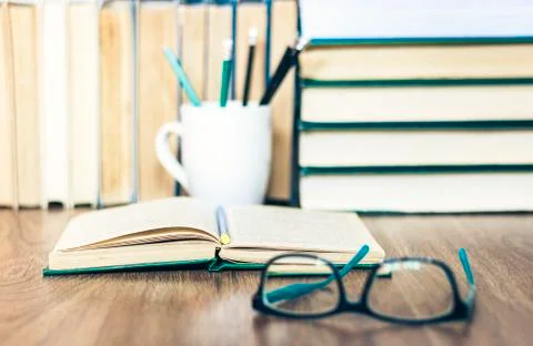Stack of books, pencils, open book, glasses, background for education learnin Stock Photos