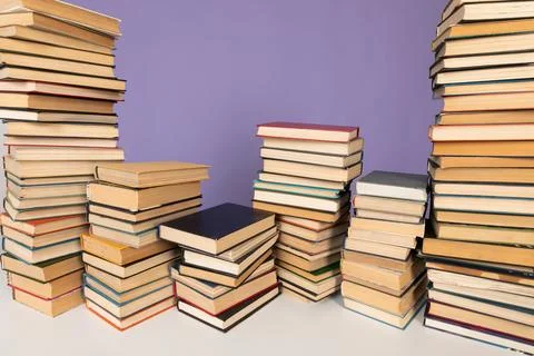 A stack of books on a purple background in the library in the office Stock Photos