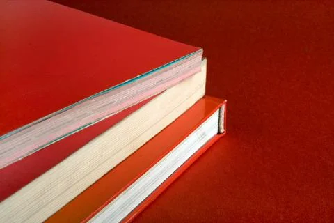 Stack of books with red covers on red background Stock Photos
