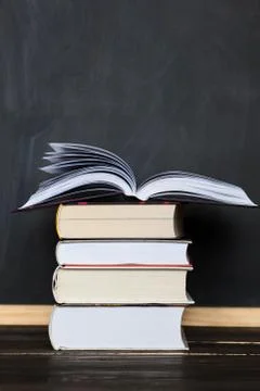 Stack of books with school chalkboard in background .  Vertical orientation Stock Photos