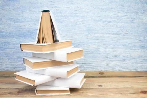 Stack of books in the shape of a Christmas tree on a blue background. Back .. Stock Photos