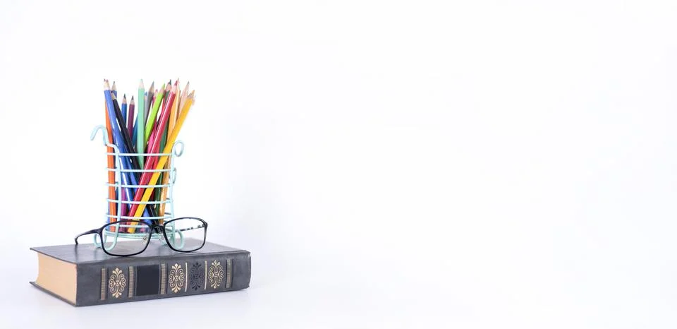 A stack of books, study guides, textbooks, glasses, and pencils in a text cop Stock Photos