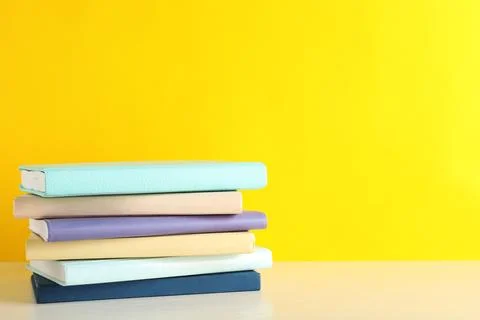 Stack of books on table against color background. Space for text 스톡 사진
