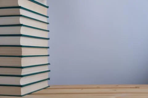 A stack of books on the table and a light background. Stock Photos