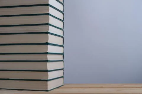 A stack of books on the table and a light background. Stock Photos
