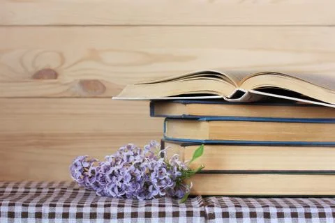 Stack of books on the table and lilacs. Foto stock