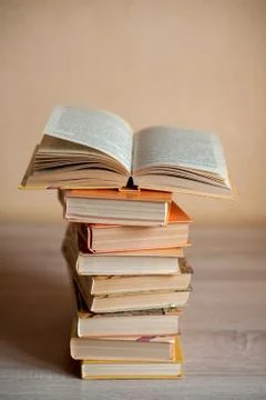 A stack of books is on the table and one book is open Stock Photos