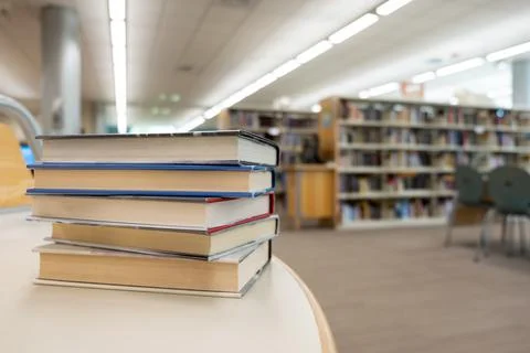 Stack of books on table at library Stock-Fotos