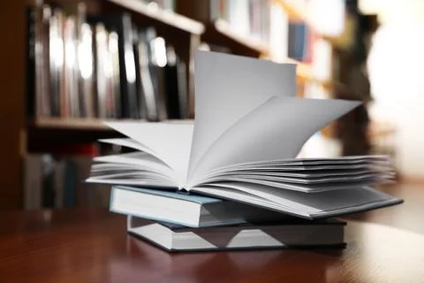 Stack of books on table in library Stock Photos