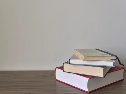 Stack of books on a table with light colored background.Education learning an Stock Photos