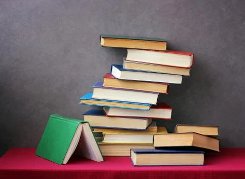 A stack of books on the table with a red tablecloth. Stock-Fotos