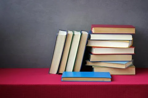 A stack of books on the table with a red tablecloth. Stock-Fotos