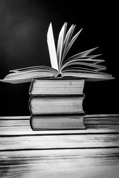 A stack of books on the table. At the top is an open book. World book day con Stock-Fotos
