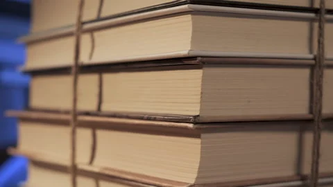 Stack of books tied with string showing pages edges in close up Stock Footage 336483493