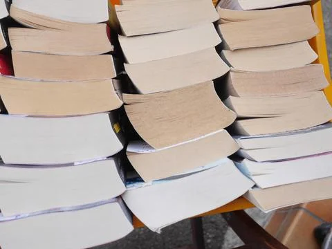A stack of books with the top one being a hardcover edition of a novel Stock Photos