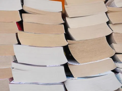 A stack of books with the top one being red Stock Photos