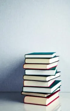 Stack of books on white reflective surface Stock Photos