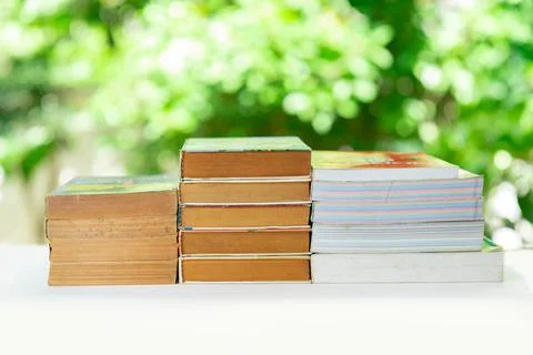 Stack of books on white table in the garden, relax time reading book . Stock-Fotos