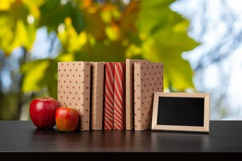 Stack of books on wooden table against blurred background Stock Photos