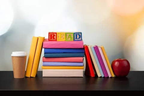Stack of books on wooden table against blurred background Foto stock
