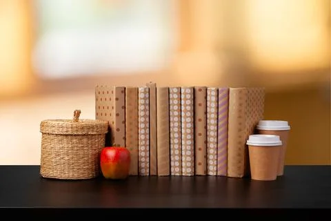 Stack of books on wooden table against blurred background Stock Photos