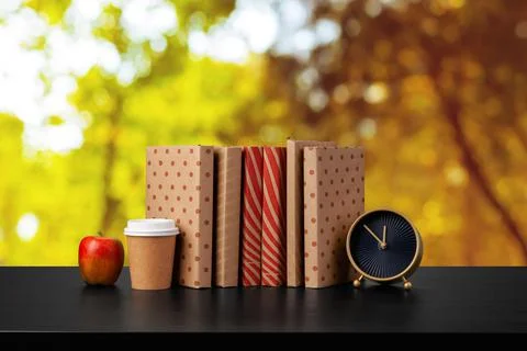Stack of books on wooden table against blurred background Stock Photos