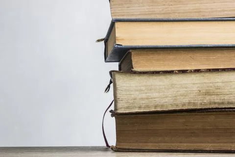Stack of books on wooden table with window light Stock Photos