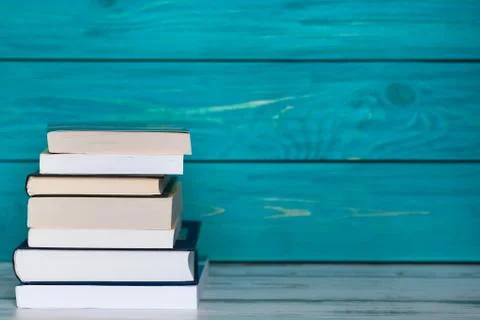 Stack of books on wooden turquoise background. Free place for text. Education Stock Photos