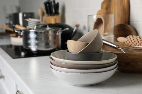Stack of bowls and different cooking utensils on countertop in kitchen, space 스톡 사진