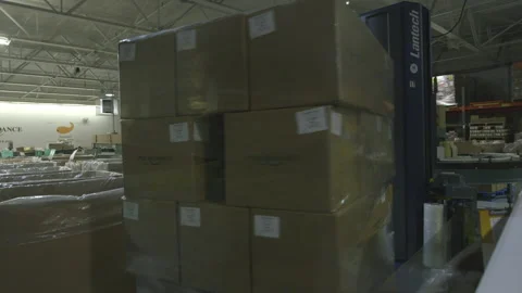 Stack of Boxes being wrapped in plastic by machine Stock Footage 139313448