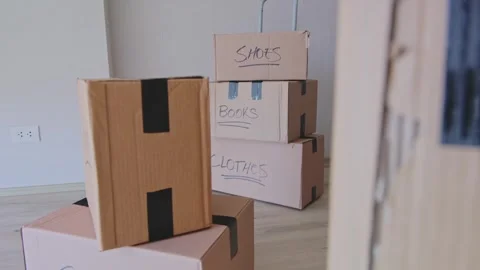A stack of boxes with the words books and clothes written on them. New house Stock Footage 315700502