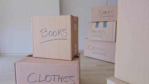 A stack of boxes with the words books and clothes written on them. New house Stock Footage 315700562