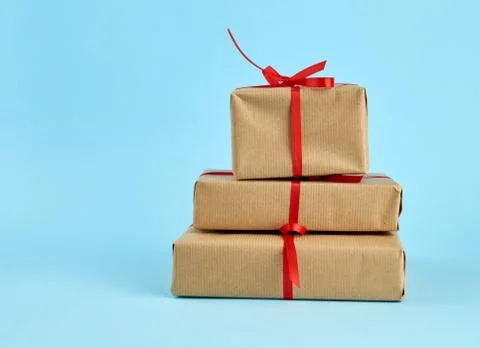 Stack of boxes wrapped in brown paper and tied with a red bow Stockfoto's