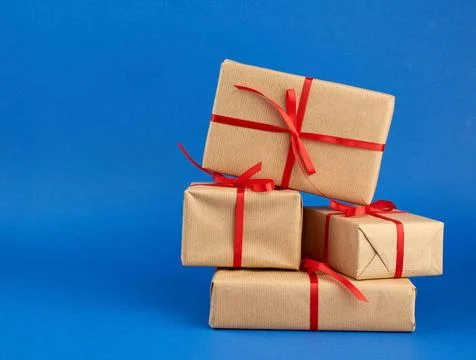Stack of boxes wrapped in brown paper and tied with a red bow stack of box... Stockfoto's