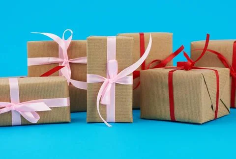 Stack of boxes wrapped in brown paper and tied with a red bow, gifts on a ... Stockfoto's