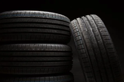 Stack of brand new high performance car tires on clean high-key white studio  Stock Photos