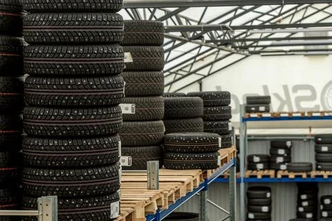 Stack of brand new studded winter car tires on wooden pallet inside logisti.. 스톡 사진