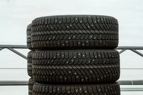 Stack of brand new studded winter tires close up with deep rubber tread for.. 스톡 사진