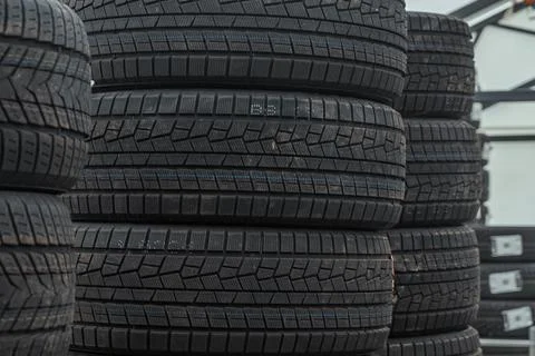 Stack of brand new winter car tires close up with focus on deep rubber trea.. 스톡 사진