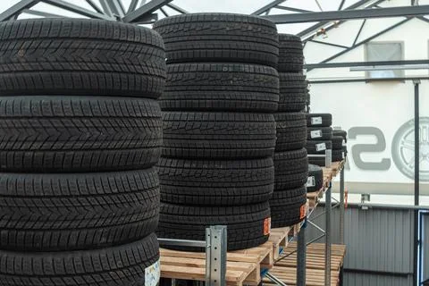 Stack of brand new winter car tires close up with focus on deep rubber trea.. 스톡 사진