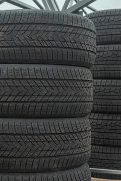 Stack of brand new winter car tires close up with focus on deep rubber trea.. 스톡 사진