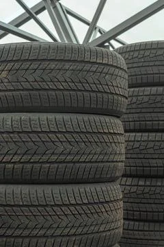 Stack of brand new winter car tires close up with focus on deep rubber trea.. 写真素材