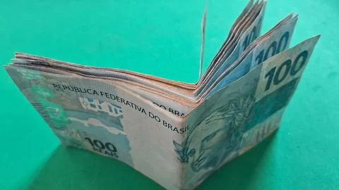 Stack of Brazilian one hundred real banknotes on green surface Stock Photos