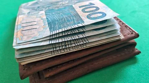 Stack of brazilian one hundred real banknotes inside brown leather wallet Stock Photos