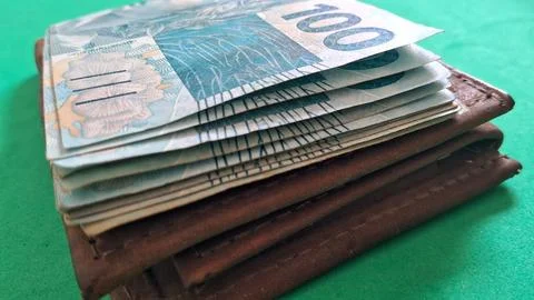 Stack of Brazilian one hundred real banknotes inside leather wallet Stock Photos