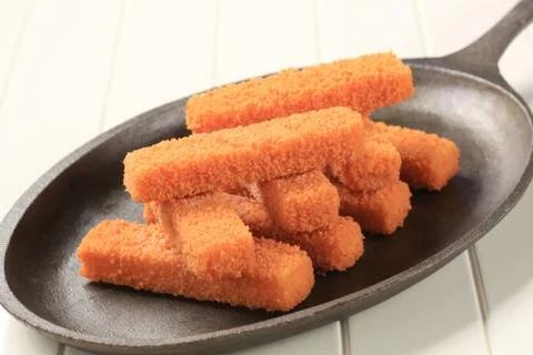 Stack of breaded fish fingers on a pan Stock Photos