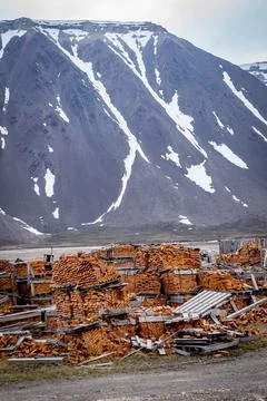 Stack of bricks and industrial material in the background of a snowy mountain, S Stock Photos