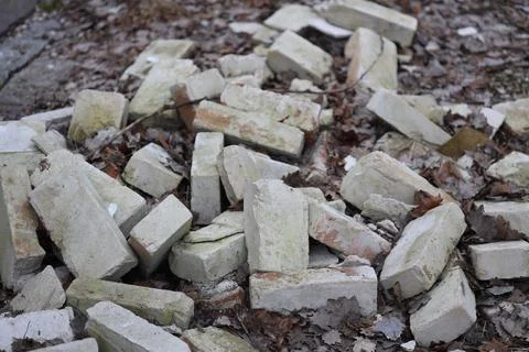 A stack of bricks lying on the grassy surface, ideal for construction or Stock Photos