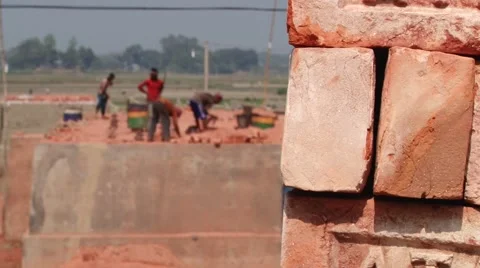 Stack of bricks with people working at the brick factory at the background. Stock-Footage 48323960